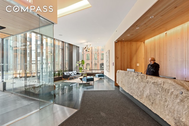 90 Furman St Unit N107, New York City, NY 11201 - welcome area featuring a wall of windows, a chandelier, and wood walls