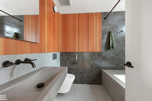 46 Great Jones St Unit 7, New York City, NY 10012 - full bathroom featuring a sink, tile walls, tile patterned floors, tiled shower, and toilet