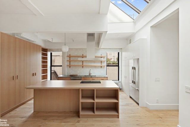 46 Great Jones St Unit 7, New York City, NY 10012 - kitchen featuring open shelves, island range hood, appliances with stainless steel finishes, and a skylight