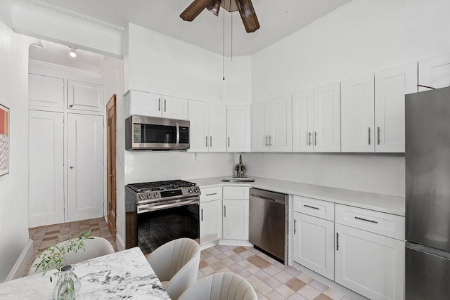 255 W 108th St Unit 2F, New York City, NY 10025 - kitchen with appliances with stainless steel finishes, light countertops, a ceiling fan, a sink, and white cabinetry