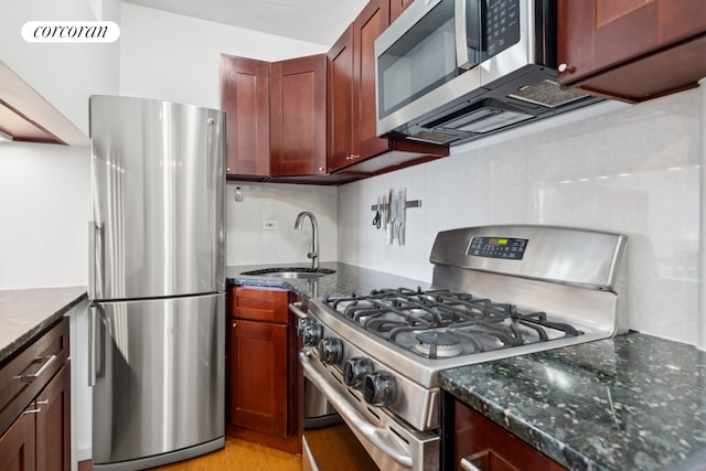 10 W 15th St Unit 1822, New York City, NY 10011 - kitchen with appliances with stainless steel finishes, a sink, tasteful backsplash, dark stone counters, and light wood-style floors