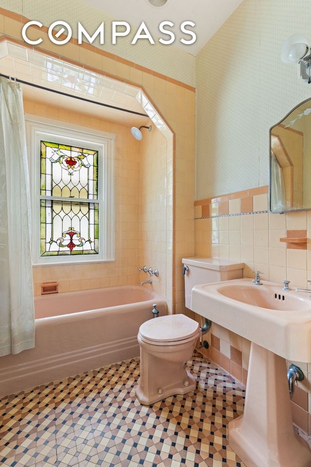 492 Westminster Rd, New York City, NY 11218 - bathroom featuring tile walls, toilet, wallpapered walls, shower / bathtub combination with curtain, and tile patterned flooring