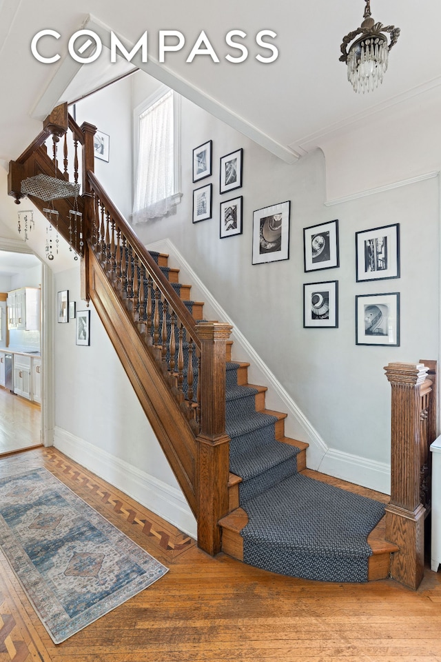 492 Westminster Rd, New York City, NY 11218 - stairway with baseboards, wood finished floors, and a chandelier