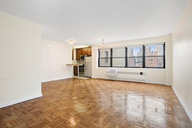 155 E 38th St Unit 19A, New York City, NY 10016 - unfurnished living room featuring radiator, a chandelier, and baseboards