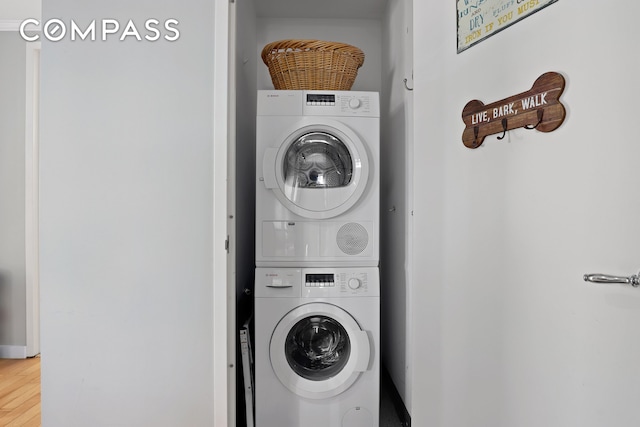 460 W 236th St Unit 65, New York City, NY 10463 - washroom featuring stacked washing machine and dryer and wood finished floors