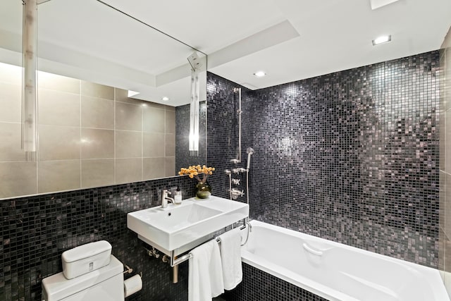 40 E 78th St Unit 7-H, New York City, NY 10075 - bathroom featuring tile walls, toilet, tiled shower / bath combo, and a sink