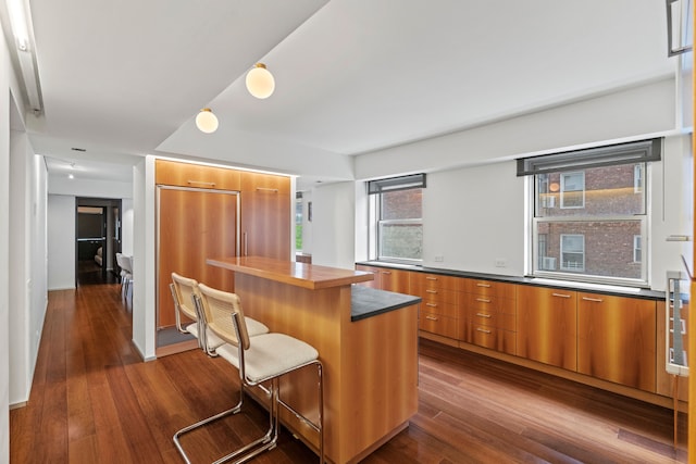 40 E 78th St Unit 7-H, New York City, NY 10075 - kitchen with modern cabinets, brown cabinetry, dark wood finished floors, and a breakfast bar