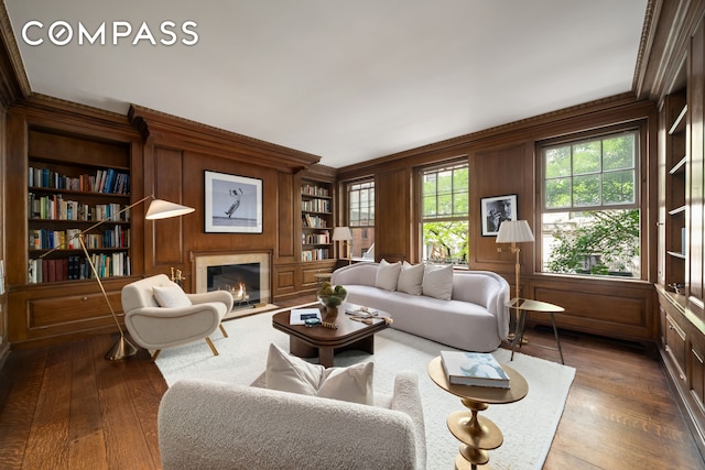 46 E 71st St, New York City, NY 10021 - living area with a premium fireplace, built in features, hardwood / wood-style flooring, crown molding, and wooden walls