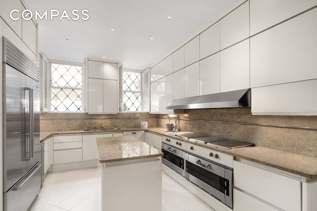 46 E 71st St, New York City, NY 10021 - kitchen with high end fridge, extractor fan, a center island, cooktop, and tasteful backsplash