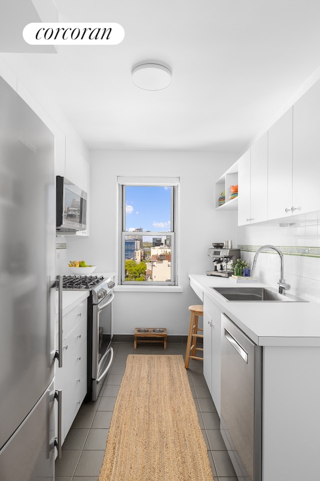 175 W 13th St Unit 14D, New York City, NY 10011 - kitchen with appliances with stainless steel finishes, a sink, light countertops, backsplash, and open shelves