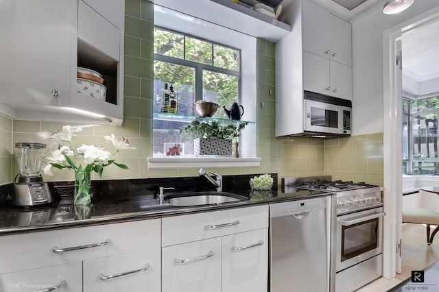 440 E 56th St Unit 1-G, New York City, NY 10022 - kitchen with stainless steel appliances, tasteful backsplash, plenty of natural light, and white cabinetry