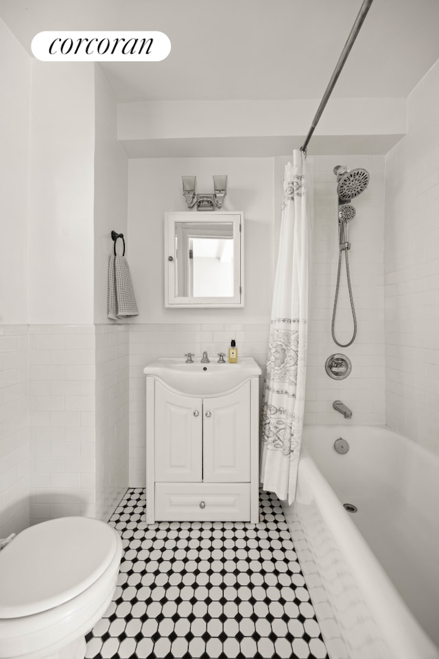304 W 75th St Unit 9H, New York City, NY 10023 - bathroom with tile walls, shower / bath combo with shower curtain, vanity, tile patterned flooring, and a wainscoted wall