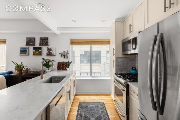 133 Water St Unit 3D, New York City, NY 11201 - kitchen with stainless steel appliances, a sink, healthy amount of natural light, light stone counters, and beam ceiling