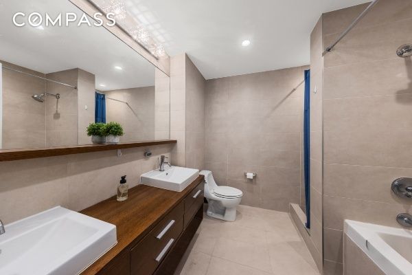 133 Water St Unit 3D, New York City, NY 11201 - bathroom featuring tile walls, tiled shower, tile patterned flooring, toilet, and a bathtub