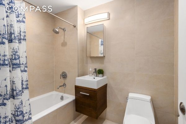 133 Water St Unit 3D, New York City, NY 11201 - bathroom with tiled shower / bath, tile walls, and vanity
