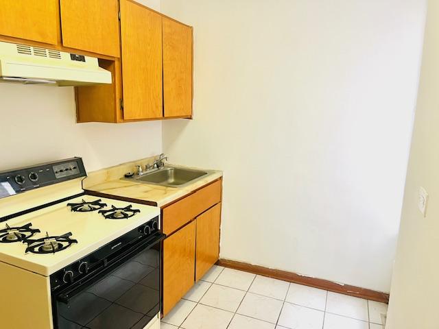 3500 Snyder Ave Unit 3R, New York City, NY 11203 - kitchen featuring range with gas cooktop, under cabinet range hood, a sink, light countertops, and baseboards