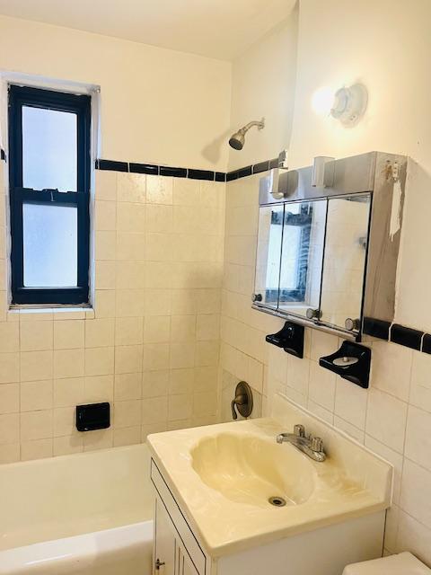 3500 Snyder Ave Unit 3R, New York City, NY 11203 - bathroom featuring tile walls, vanity, toilet, and shower / washtub combination