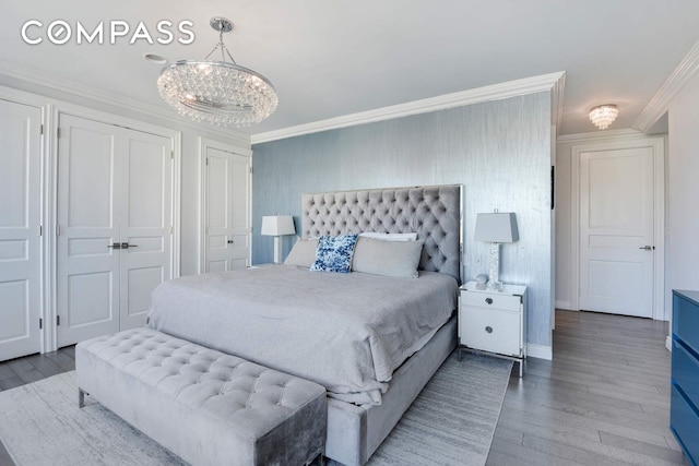 201 E 80th St Unit 16E, New York City, NY 10075 - bedroom featuring two closets, wood finished floors, ornamental molding, a chandelier, and baseboards