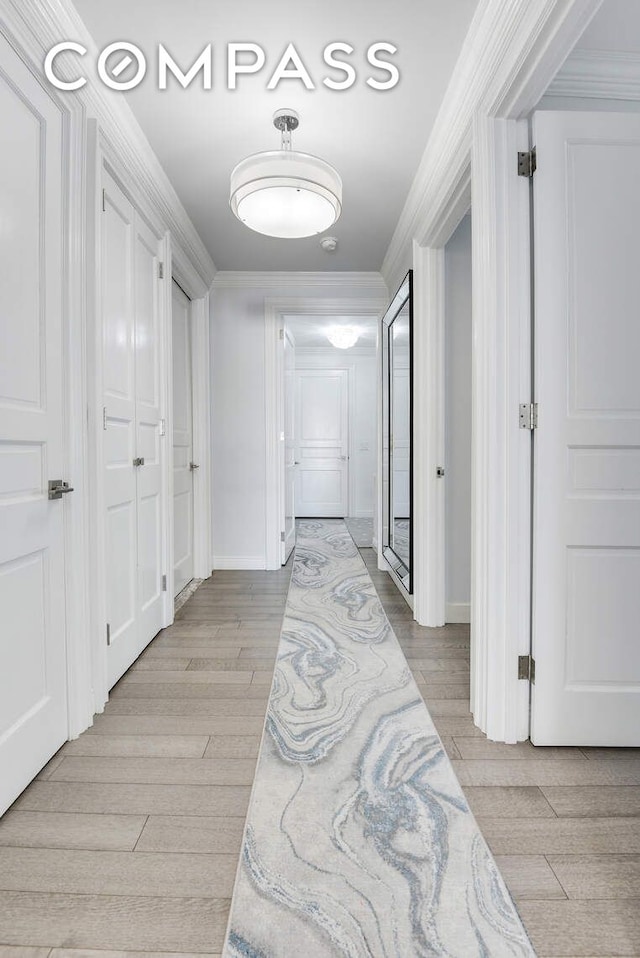 201 E 80th St Unit 16E, New York City, NY 10075 - hallway featuring light wood-style flooring, ornamental molding, and baseboards