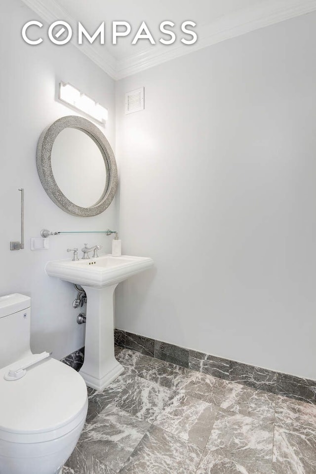 201 E 80th St Unit 16E, New York City, NY 10075 - half bath with toilet, baseboards, crown molding, and marble finish flooring