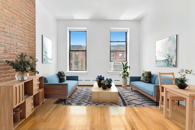 161 W 133rd St Unit 3-B, New York City, NY 10030 - living room featuring cooling unit, light wood finished floors, and brick wall