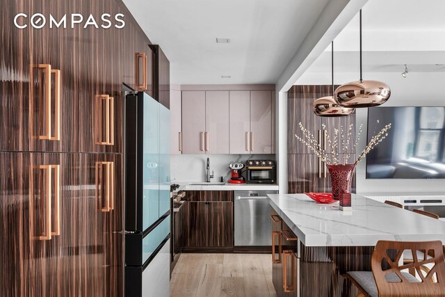 201 W 74th St Unit 8G, New York City, NY 10023 - kitchen featuring modern cabinets, light wood-style floors, dishwasher, a sink, and a breakfast bar