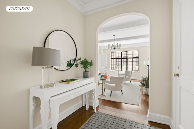 125 E 74th St Unit 2B, New York City, NY 10021 - hall with dark wood finished floors, arched walkways, a chandelier, ornamental molding, and baseboards
