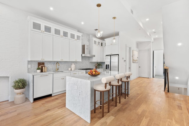 129 W 131st St Unit 1A, New York City, NY 10027 - kitchen with stainless steel fridge, a sink, wall chimney exhaust hood, decorative backsplash, and white cabinetry