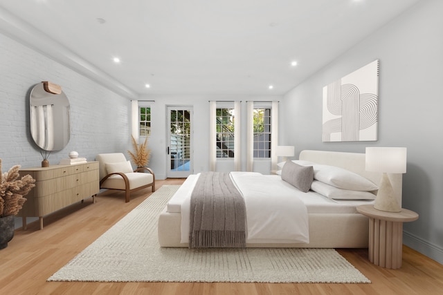 129 W 131st St Unit 1A, New York City, NY 10027 - bedroom with access to outside, light wood-style flooring, recessed lighting, and brick wall