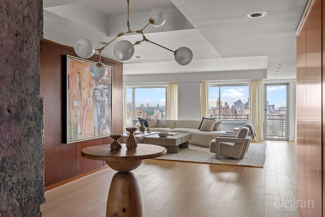 118 E 60th St Unit 33/32Duplex, New York City, NY 10022 - living room featuring a view of skyline, plenty of natural light, and light wood finished floors