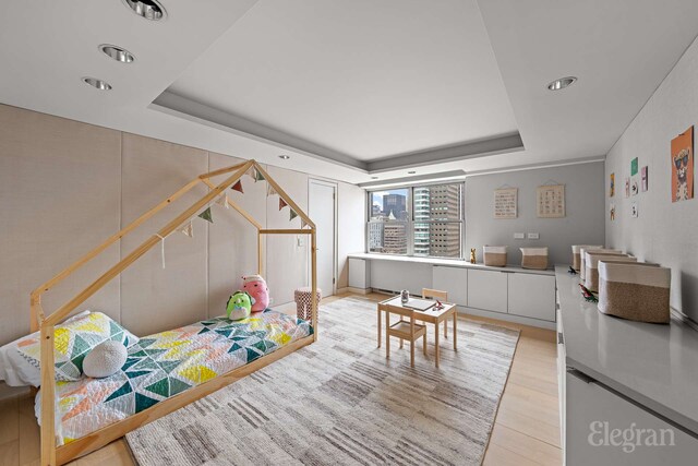 118 E 60th St Unit 33/32Duplex, New York City, NY 10022 - bedroom featuring a tray ceiling, recessed lighting, and light wood-type flooring