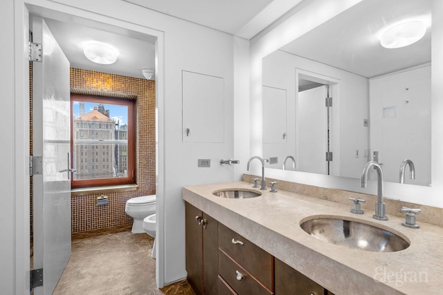 118 E 60th St Unit 33/32Duplex, New York City, NY 10022 - bathroom featuring a bidet, toilet, double vanity, and tile walls