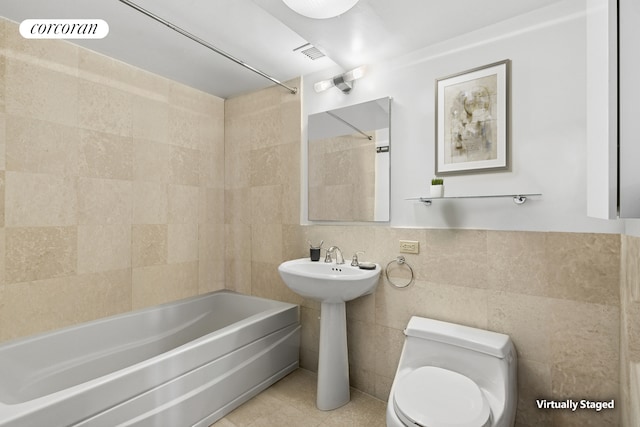 1485 5th Ave Unit 19C, New York City, NY 10035 - bathroom featuring toilet, shower / bath combination, tile walls, a sink, and tile patterned flooring
