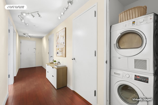 1485 5th Ave Unit 19C, New York City, NY 10035 - laundry area featuring stacked washer / dryer, dark wood-type flooring, and baseboards