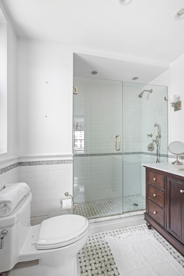 45 E 85th St Unit 7E, New York City, NY 10028 - bathroom with toilet, a stall shower, a wainscoted wall, vanity, and tile walls