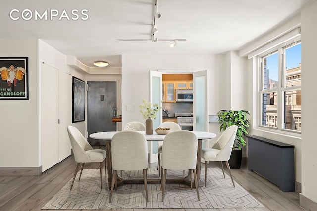 142 E 16th St Unit 22B, New York City, NY 10003 - dining area with light wood finished floors, baseboards, a chandelier, and track lighting