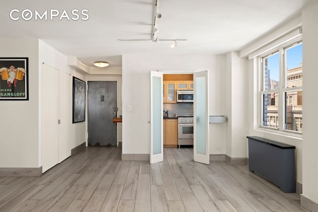 142 E 16th St Unit 22B, New York City, NY 10003 - unfurnished living room with light wood-type flooring and baseboards