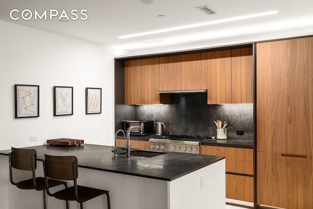 856 Washington Ave Unit 5A, New York City, NY 11238 - kitchen with dark countertops, decorative backsplash, modern cabinets, and a sink