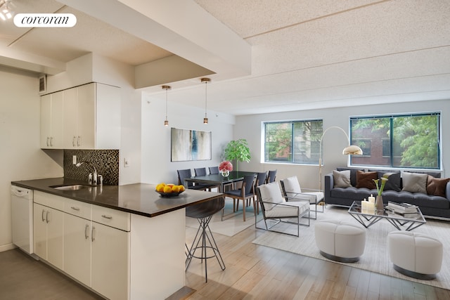 333 E 119th St Unit 1A, New York City, NY 10035 - kitchen featuring a sink, dishwasher, dark countertops, open floor plan, and a kitchen breakfast bar