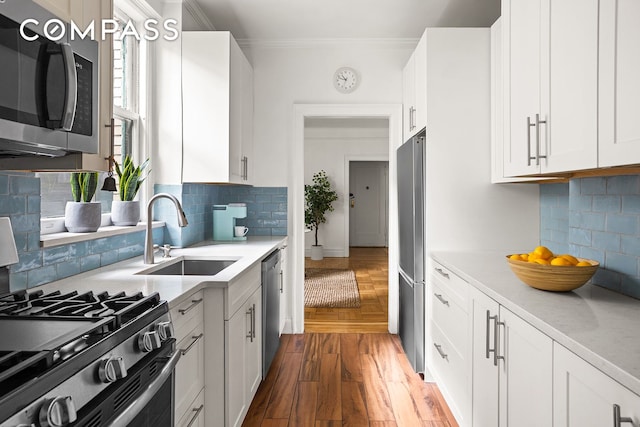 35-47 80th St Unit 2, New York City, NY 11372 - kitchen with stainless steel appliances, a sink, ornamental molding, wood finished floors, and light countertops
