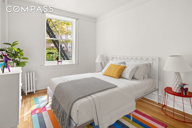 35-47 80th St Unit 2, New York City, NY 11372 - bedroom with radiator heating unit, wood finished floors, and baseboards