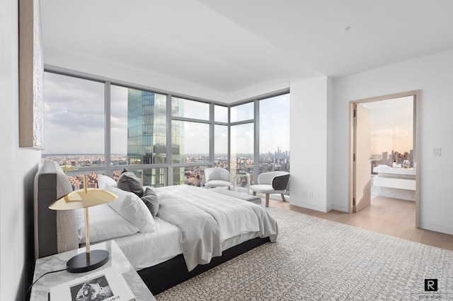 23 E 22nd St Unit 55, New York City, NY 10010 - bedroom featuring wood finished floors, multiple windows, and ensuite bathroom