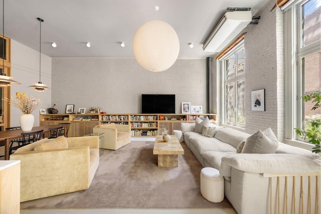 132 Greene St Unit 3R, New York City, NY 10012 - living room with healthy amount of natural light, brick wall, and carpet