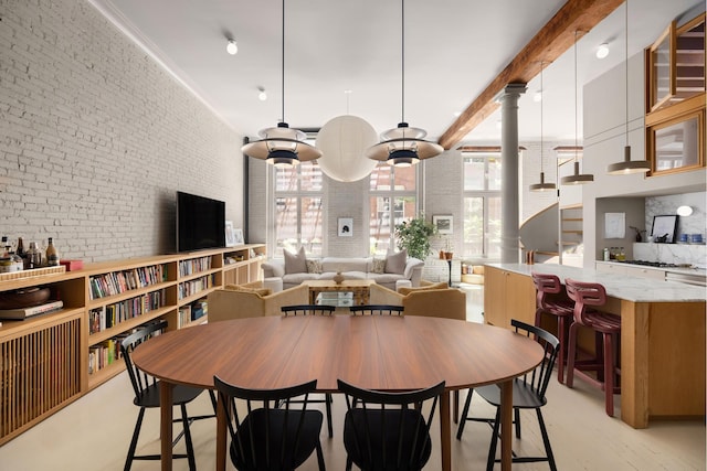 132 Greene St Unit 3R, New York City, NY 10012 - dining area featuring brick wall and light wood-style floors
