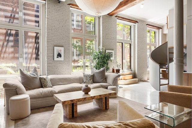 132 Greene St Unit 3R, New York City, NY 10012 - living area with brick wall, a high ceiling, and beam ceiling