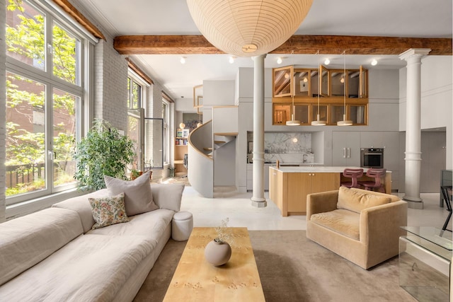 132 Greene St Unit 3R, New York City, NY 10012 - living room featuring decorative columns, beam ceiling, and a towering ceiling