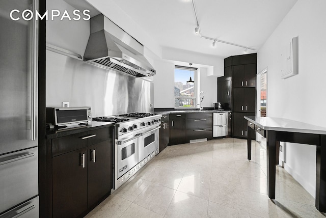 12 Beekman Place Pha, New York City, NY 10022 - kitchen with appliances with stainless steel finishes, wall chimney exhaust hood, dark countertops, dark cabinets, and light tile patterned floors