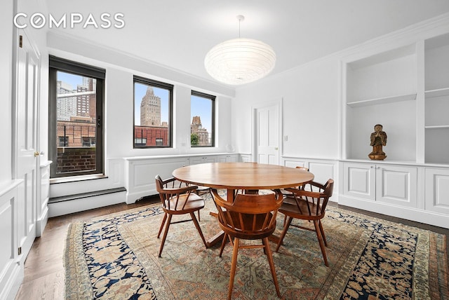 12 Beekman Place Pha, New York City, NY 10022 - dining area featuring baseboard heating, plenty of natural light, a decorative wall, crown molding, and a wainscoted wall