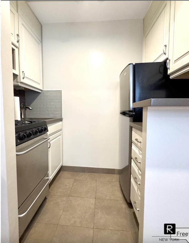 233 E 69th St Unit 3-O, New York City, NY 10021 - kitchen featuring stainless steel gas range, white cabinets, decorative backsplash, and light tile patterned floors