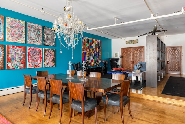 351 W Broadway Unit 4, New York City, NY 10013 - dining area featuring wood finished floors, rail lighting, a chandelier, and a baseboard heating unit